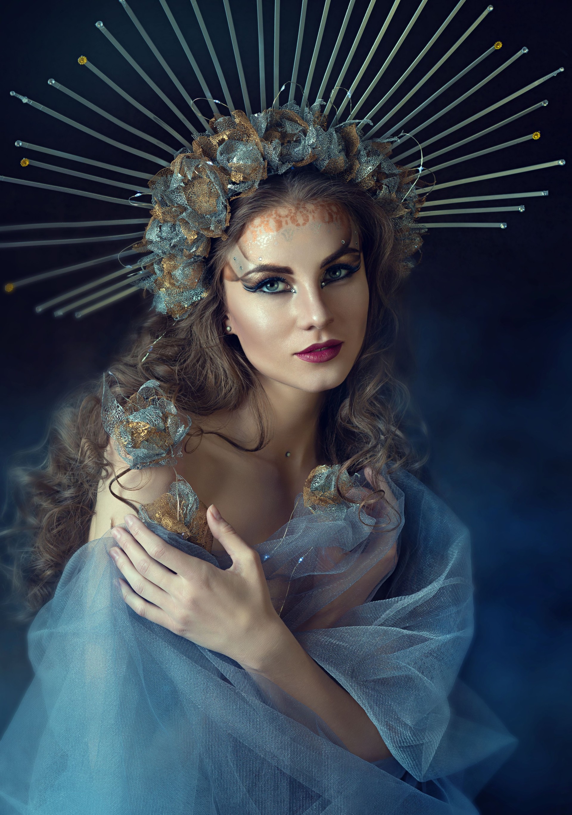 a young beautiful woman - a queen in a chic crown. artistic portrait of a princess. Mystical image. makeup and hairstyle. Brown-haired woman with d